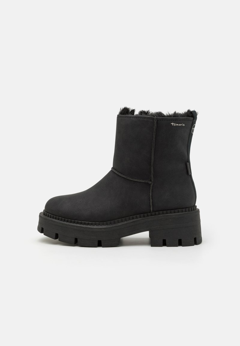 Botas negras hasta el tobillo con parte superior sintética texturizada, forro suave en el cuello y suela de goma gruesa que presenta un patrón de tracción.