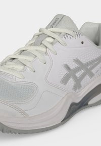 Λευκό και γκρι αθλητικό παπούτσι ASICS με πάνελ από δίχτυ, υφασμένη σόλα και κλείσιμο με κορδόνια σε απλό φόντο.