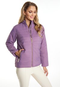 Giacca trapuntata viola con colletto alto, tasche laterali e zip dorate. Texture liscia con dettagli di cucitura orizzontale.