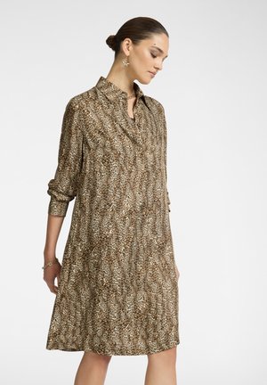 Abito camicia con stampa leopardata marrone, con chiusura a bottoni frontale, maniche lunghe e silhouette A-line rilassata. Tessuto morbido con una trama liscia.