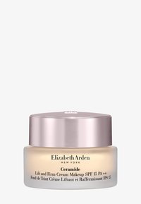 Krem Ceramide Lift and Firm Makeup w okrągłym szklanym opakowaniu. Miękki krem o przezroczystej bazie, metalicznie różowa pokrywka, czarny tekst i detale.