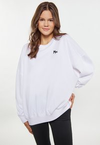Felpa bianca oversize con il logo ricamato "Mrs." in nero. Presenta un collo a giro e una vestibilità rilassata con polsini e orlo a coste.