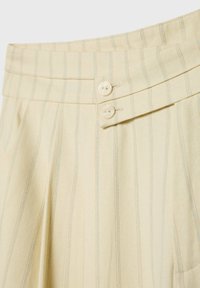 Jupe en tissu crème avec de fines rayures verticales bleues, dotée d'une ceinture avec deux boutons blancs sur le côté.