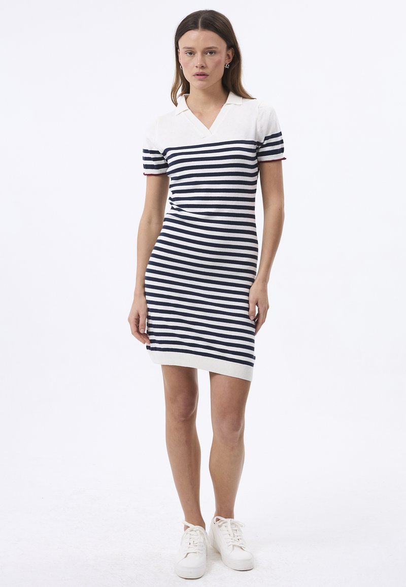 Abito polo a maglia con strisce orizzontali blu navy e bianche, maniche corte, scollo a V e una silhouette aderente con orlo sopra il ginocchio.
