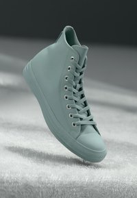 Hochschnittsneaker aus mattem mintgrünem Leder, mit Metallösen, flachen Schnürsenkeln und einer strukturierten Gummisohle mit abgerundetem Zehenkapp.