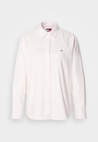 Svjetloružičasta košulja dugih rukava na dugme od pamuka, s klasičnom kragnom i malim logotipom branda na lijevoj strani prsnog koša.