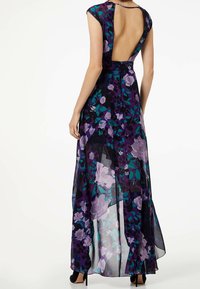 Kukkakuvioinen maksimekko ohuesta mustasta kankaasta, jossa on hihattomat mallit, avoin selkäosa ja purppuran sekä turkoosin sävyjä suunnittelussa.