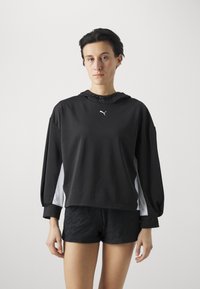 Sudadera con capucha negra y acentos blancos, de corte relajado y mangas largas. Presenta un pequeño logo en el pecho y un cordón en la capucha.