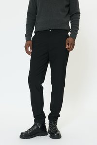 Juodos kelnės iš lygaus audinio, plono kirpimo su priekinių kišenių detalėmis. Derinamos su juodais bateliais su raišteliais ir metalinėmis detalėmis.