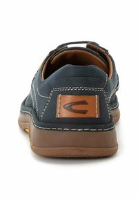 Navyblaues Wildleder-Slipper mit braunen Lederakzenten und kontrastierenden weißen Nähten. Abgerundete Rückseite mit einer strukturierten Gummisohle.