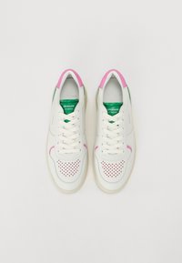 Vita lädersneakers med rosa detaljer på hälen och sidan, med perforerade detaljer, gröna innersulor och platta vita skosnören.