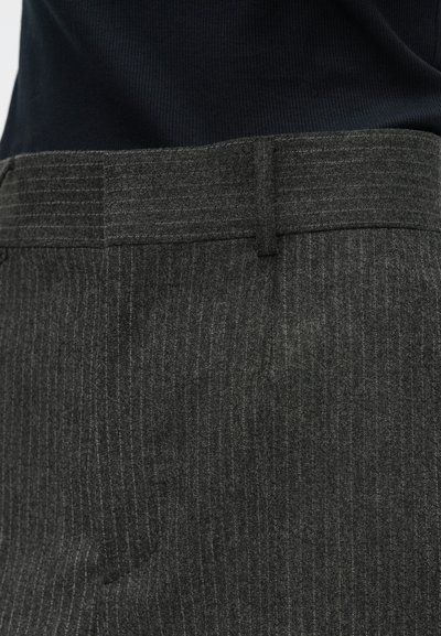 Grey pinstripe trousers with a smooth texture, featuring a tailored waistband and subtle pleats, shown against a dark fabric background.