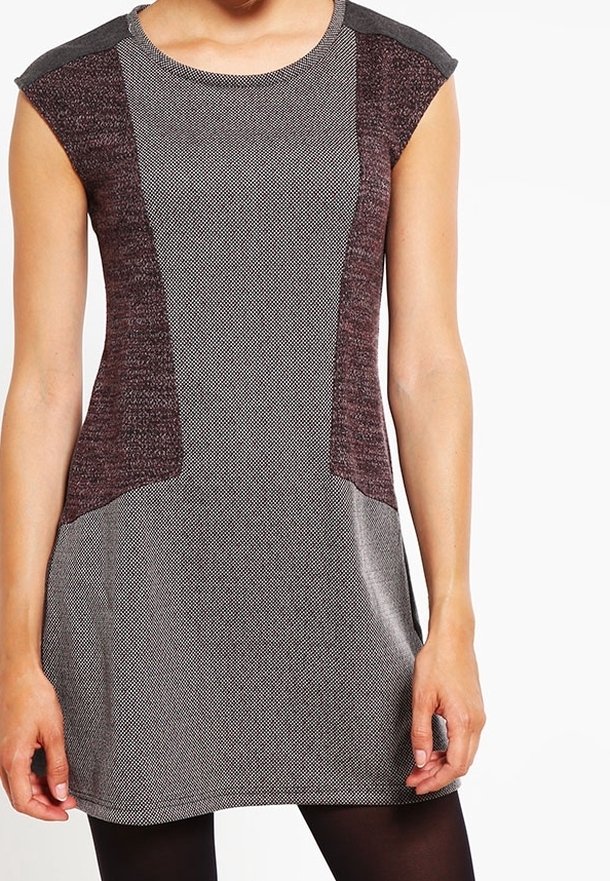 Robe sans manches avec un corps texturé gris et des panneaux latéraux bordeaux. Encolure ronde et tissu doux et lisse avec une coupe décontractée.