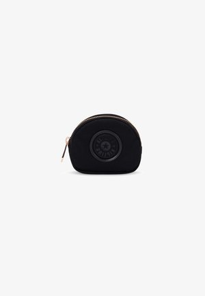Monedero de tela negra con forma redondeada, cierre de cremallera y un acento de logo circular en la parte frontal. Textura suave, diseño compacto.