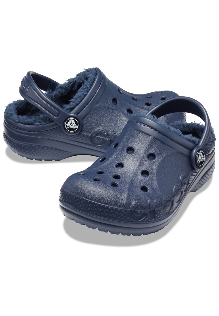 Zoccoli blu navy con un morbido rivestimento interno in peluche, dotati di fori di drenaggio e di un robusto cinturino sul tallone, realizzati in materiale leggero.