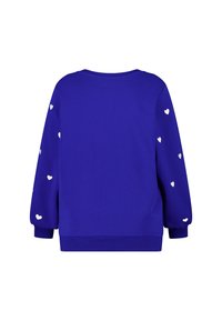 Sweat-shirt bleu à manches longues, orné de petits motifs de cœurs blancs sur les manches. Confectionné en tissu doux, avec une coupe décontractée et des poignets côtelés.