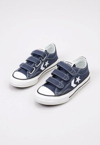 Baskets en toile bleu marine avec trois bandes Velcro, logo en forme d'étoile blanche, embout en caoutchouc et semelle extérieure blanche avec bord noir.