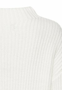 Weißer Strickpullover mit hohem Kragen. Hat eine gerippte Textur und ein horizontales Muster, das ein weiches, gemütliches Erscheinungsbild zeigt.