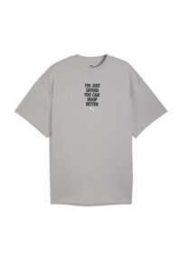 Camiseta de algodón gris con cuello redondo, con texto en negro y gris oscuro, y un pequeño logo blanco en la parte inferior. Mangas cortas.
