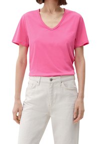 Rosa bomull t-shirt med v-hals och korta ärmar, tillsammans med ljusfärgade jeans i denim med knäppning och framfickor.