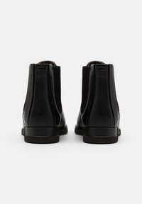 Black leather ankle boots with elastic side panels, rounded toe, smooth texture, and low block heel. Detail stitching on the back.
