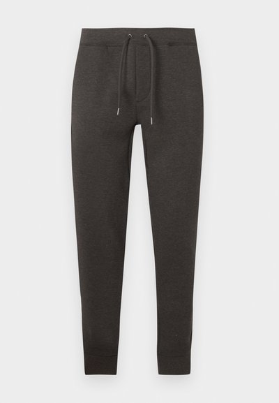 Pantalon de survêtement gris foncé en matière douce, doté d'une ceinture élastique avec cordon de serrage, jambes fuselées et poignets à la cheville.