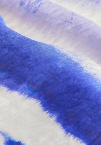 Tessuto intrecciato con un gradiente di tonalità blu su fondo bianco, con una consistenza morbida e motivi astratti simili a acquerello.