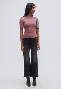 Ελαφρύ κόκκινο ριπ κοντομάνικο τοπ συνδυασμένο με ψηλόμεσα μαύρα καμπάνα τζιν και μυτερές μαύρες μποτάκια αστραγάλου. Διαθέτει εφαρμοστή σιλουέτα.