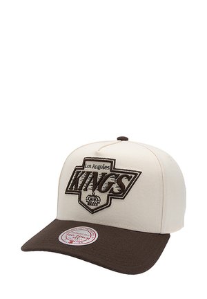Kremowa czapka z brązowym daszkiem, z haftem "Los Angeles KINGS" w brązowym kolorze i wzorem korony. Duże, okrągłe logo marki na daszku.