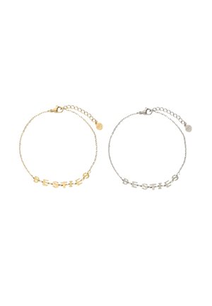 Gold- und Silberkettchen-Armbänder, jeweils mit Buchstabenanhängern, die "BESTIES" buchstabieren, und verstellbaren Verschlüssen mit kleinen runden Tags.