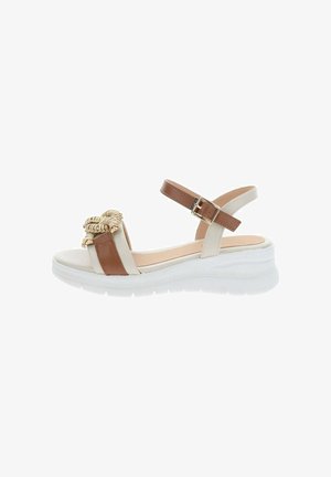 Sandalia de plataforma blanca y beige con correa en el tobillo, cierre de hebilla y detalle decorativo trenzado en la correa delantera.