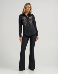 Camisa preta de mangas longas com fecho de botão, apresentando intrincados desenhos em bordado dourado na frente. Textura suave e corte ajustado.
