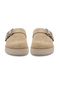 Beige velúr slip-on cipők lekerekített orral, oldalukon fémből készült csattal és világos színű gumitalppal.