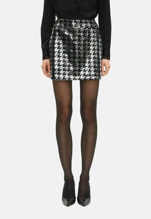 Black and silver sequined mini skirt with houndstooth pattern, smooth texture, and fitted design, paired with black tights and heels.