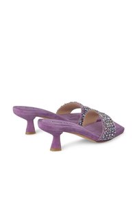 Mule aperte in suede viola con punta aperta, caratterizzate da una fascetta decorata con vari dettagli scintillanti e un tacco corto a campana.