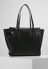 Black leather tote bag with two long handles, a structured shape, smooth texture, and minimalistic design featuring no visible hardware or accents.