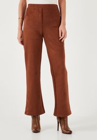 Braune, weite Hosen aus einem weichen, samtartigen Material mit glatter Textur. Hat eine flache Vorderseite und einen leichten Schlag am Saum.