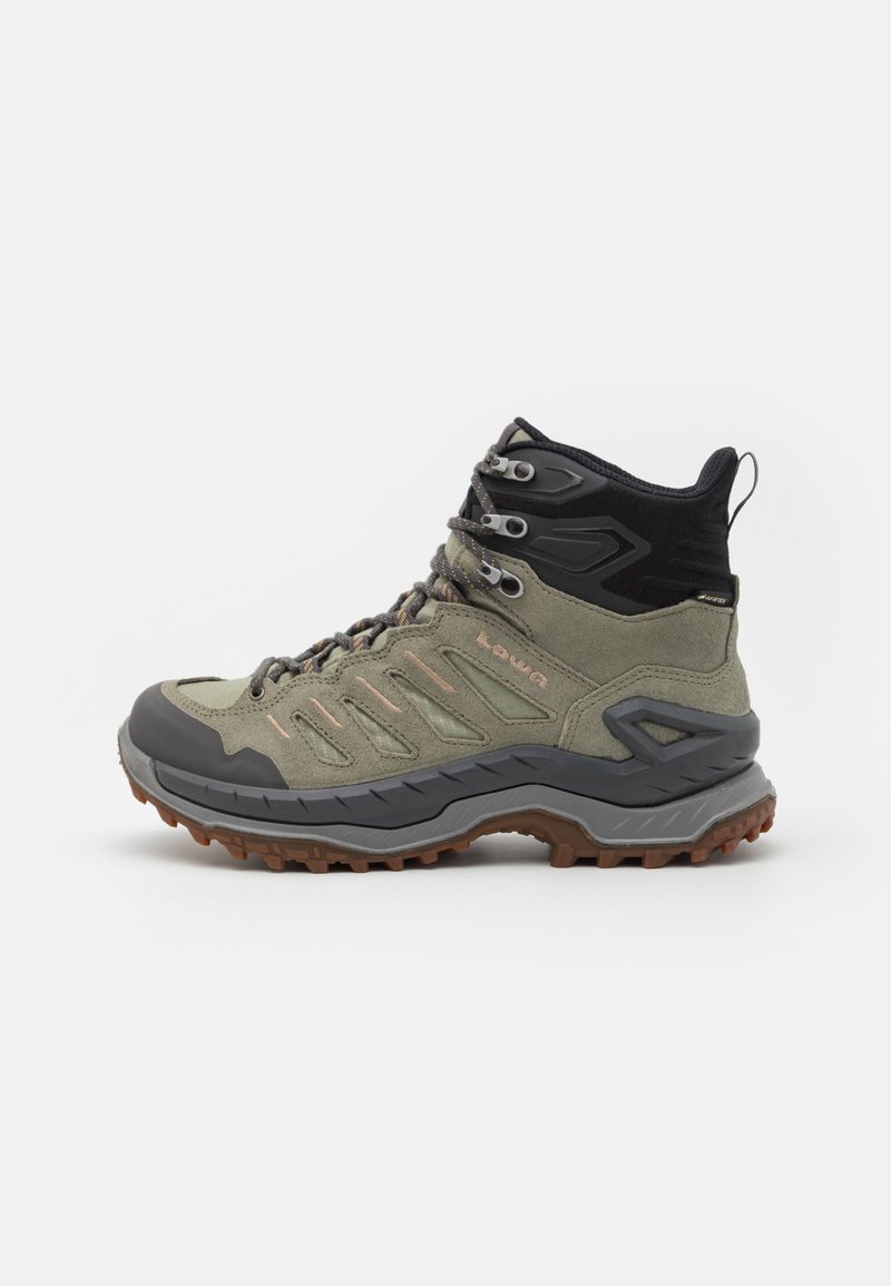 Scarpa da trekking a metà altezza realizzata in suede verde con dettagli in gomma grigia, punta rinforzata e suola texturizzata per una migliore trazione. Presenta occhielli in metallo.