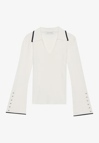 White ribbed sweater with a V-neck and pointed collar, featuring black trim on the collar and bell sleeves with silver button accents.