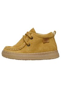 Stivale alla caviglia in suede giallo con punta rotonda, cuciture decorative, due occhielli e suola in gomma marrone. Presenta un'etichetta con il marchio sul lato.