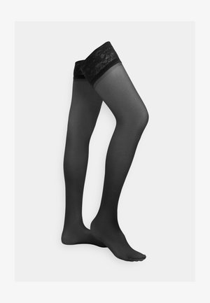 Crne čarape do bedara s prozirnim završetkom i čipkanim vrhom. Čipka ima cvjetni uzorak s glatkom teksturom duž noge.