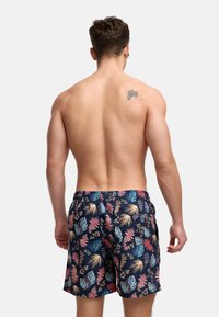 Marine svømshorts med et flerfarget tropisk bladmønster, elastisk midje og en avslappet passform, med en jevn tekstur.