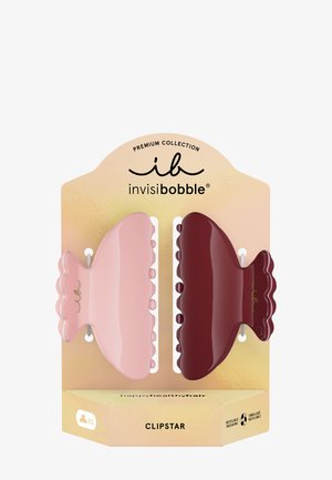 To store bølgede hårclips i pink og mørkerød, vist på guldfarvet emballage med mærket "invisibobble Clipstar."