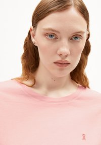 T-shirt di cotone rosa chiaro con scollatura rotonda e maniche corte, con un piccolo logo ricamato sull'area sinistra del petto.