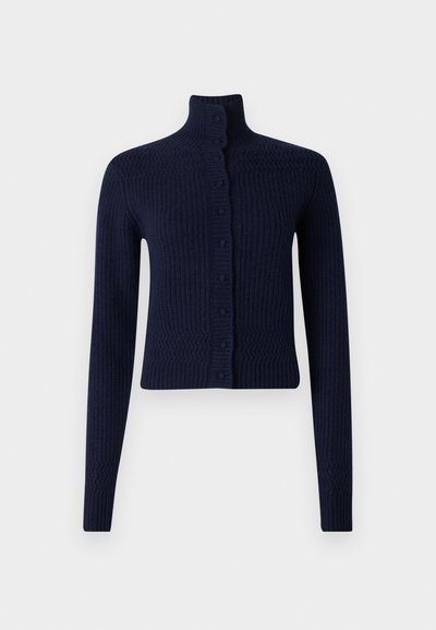 Ναυτική μπλε ριγωτή πλεκτή ζακέτα με υψηλό λαιμό, μακριά μανίκια και κουμπιά μπροστά. Το υλικό φαίνεται μαλακό με υφή στην επιφάνειά του.