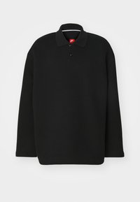 Svart långärmad polo med klassisk krage, tillverkad av ett strukturerat tyg. Har en tre-knapplåsfunktion och en röd logotag.