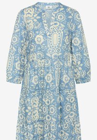 Abito azzurro chiaro realizzato in tessuto con motivi floreali e decorativi bianchi, caratterizzato da un colletto a V e maniche a tre quarti.