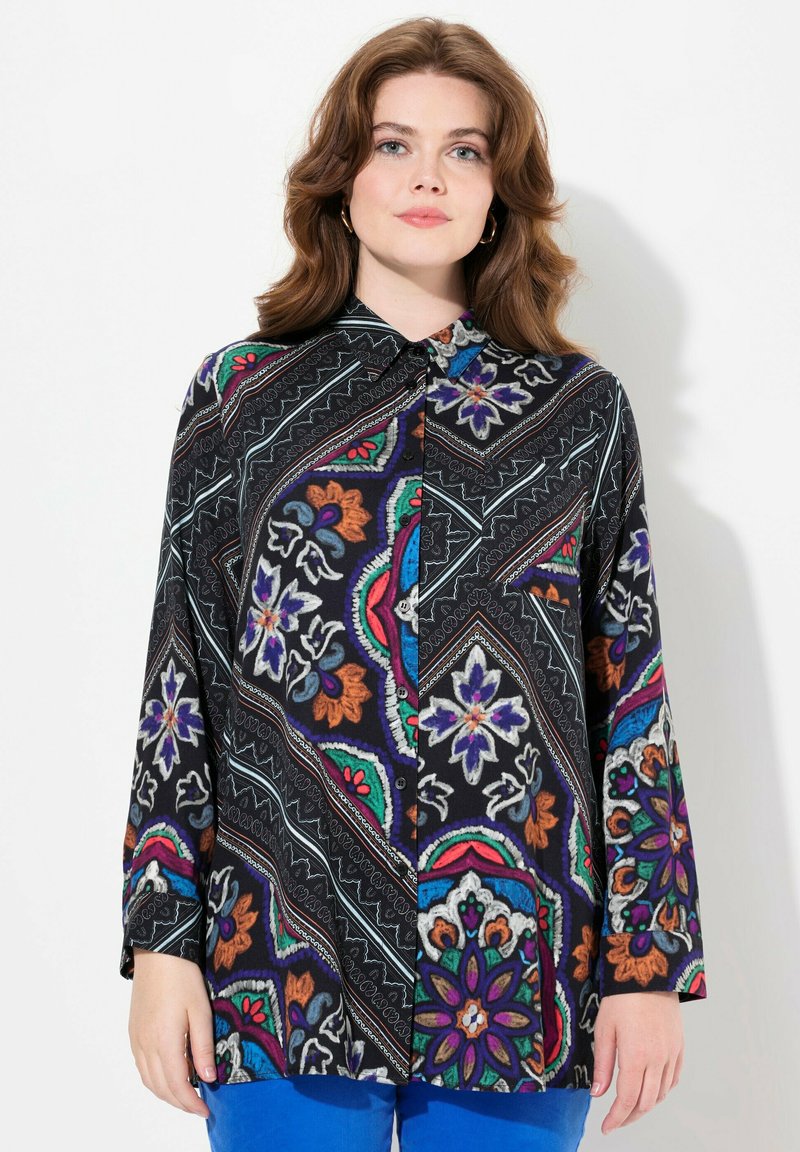 Camicia nera con bottoni, caratterizzata da motivi floreali e geometrici colorati, maniche lunghe, colletto a punta e una vestibilità comoda.
