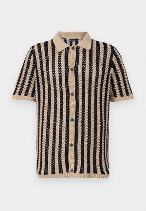 Pleteni polo s kratkimi rokavi v bež in črni barvi, ki ima navpične črte, rebrast ovratnik in zapenjanje na gumbe. Teksturna pletenina.