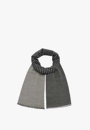 Sweter z dzianiny z geometrycznym wzorem w kolorze czarnym i beżowym, z frędzlami na brzegach i pętlowym designem ułatwiającym noszenie.